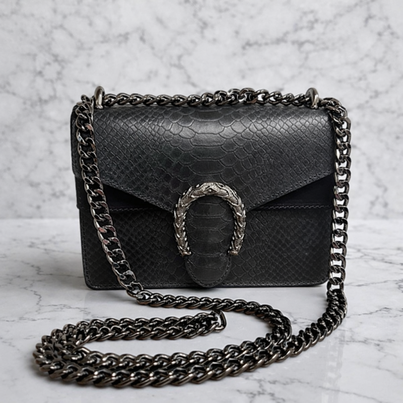 Borsa in pelle con lavorazione effetto rettile e inserti in camoscio. tracolla in metallo color canna di fucile e chiusura gioiello a forma di ferro di cavallo. Bottega della Principessa