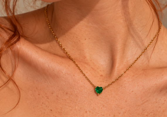 collana in acciaio inossidabile con ciondolo punto luce a forma di cuore verde smeraldo in cristallo del brand italiano di gioielli Bottega della principessa, indossata