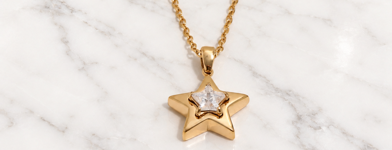 Collana Stella dorata con zirconia cubica su marmo bianco