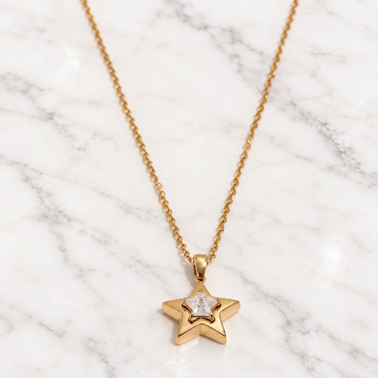 Collana Stella dorata con zirconia cubica su marmo bianco
